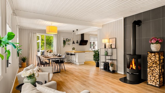 Kjøkken, spisestue og stue med åpen løsning har store vinduer som slipper inn mengder av lys.