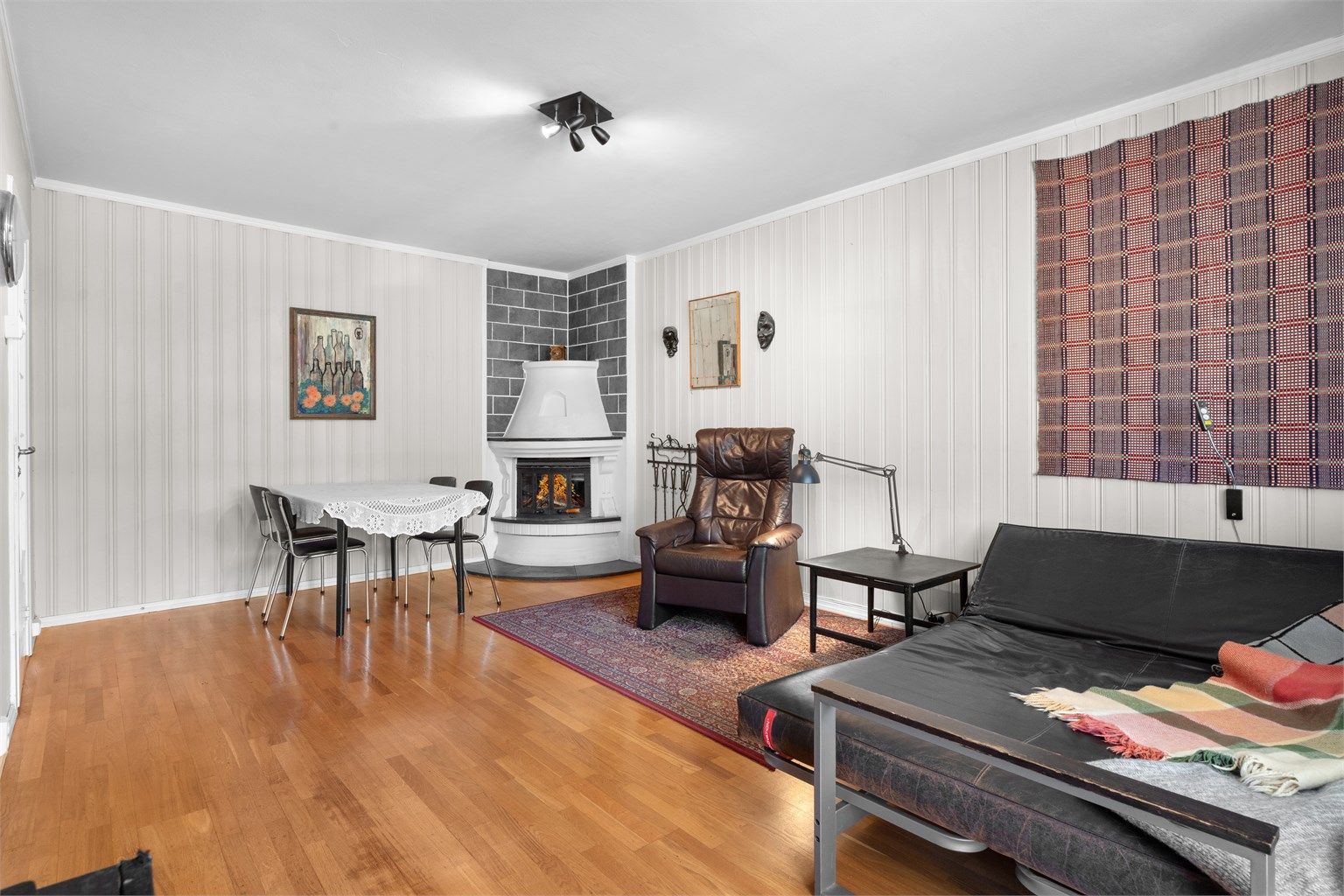 Stue med peis og plass for både sofa- og spisestue. Foto: Oh Shots
