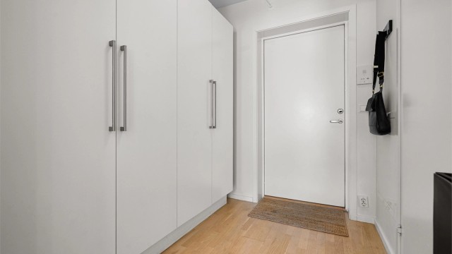 Entré med god plass til oppheng av yttertøy og oppbevaring av sko. Her er det god plass til både skoskap og romslig garderobeskap. Adkomst via fellestrappeoppgang. Leiligheten har trappefri adkomst, men det er både trapp og heis i bygget.