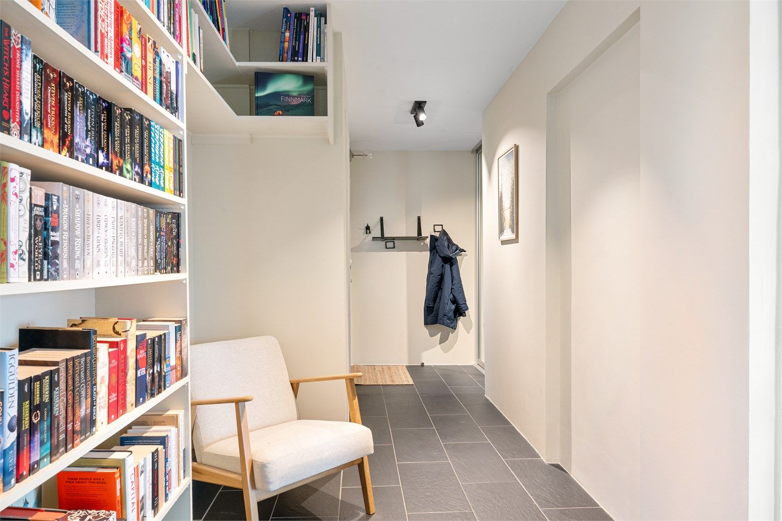 Inngangspartiet har skyvedørsgarderobe med speil, og kroker til å henge fra seg