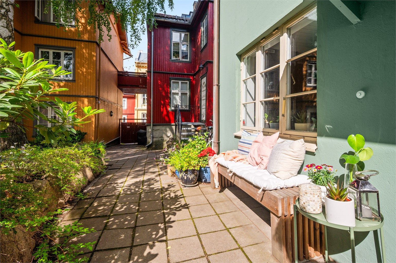 Ved inngangspartiet finner du en trivelig uteplass som ser ut over den sjarmerende trehusbebyggelsen og den grønne bakgården.