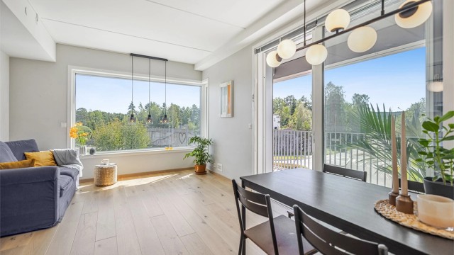 Stuen har store vindusflater som fyller rommet med naturlig lys.