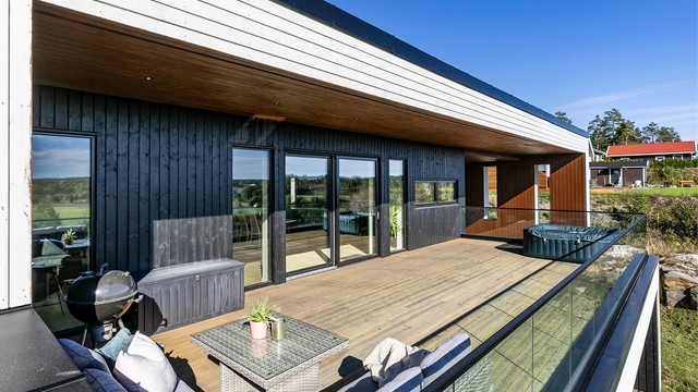Den hvite hovedfasaden er stram og moderne, mørkere felt tilfører varme og kontrast.