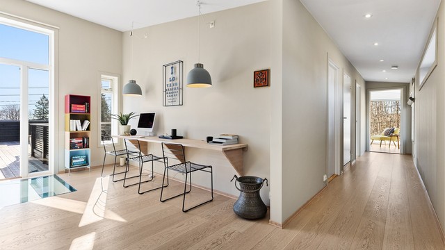 Opp trappen i 2.etasje kommer du først til stuen. Her er det plass til sittegruppe, TV-område og skrivebord/kontorløsning. Stilig detalj med glassgulv ned mot entreen i 1.etasje. Fra stuen er det utgang til en stor takterrasse.