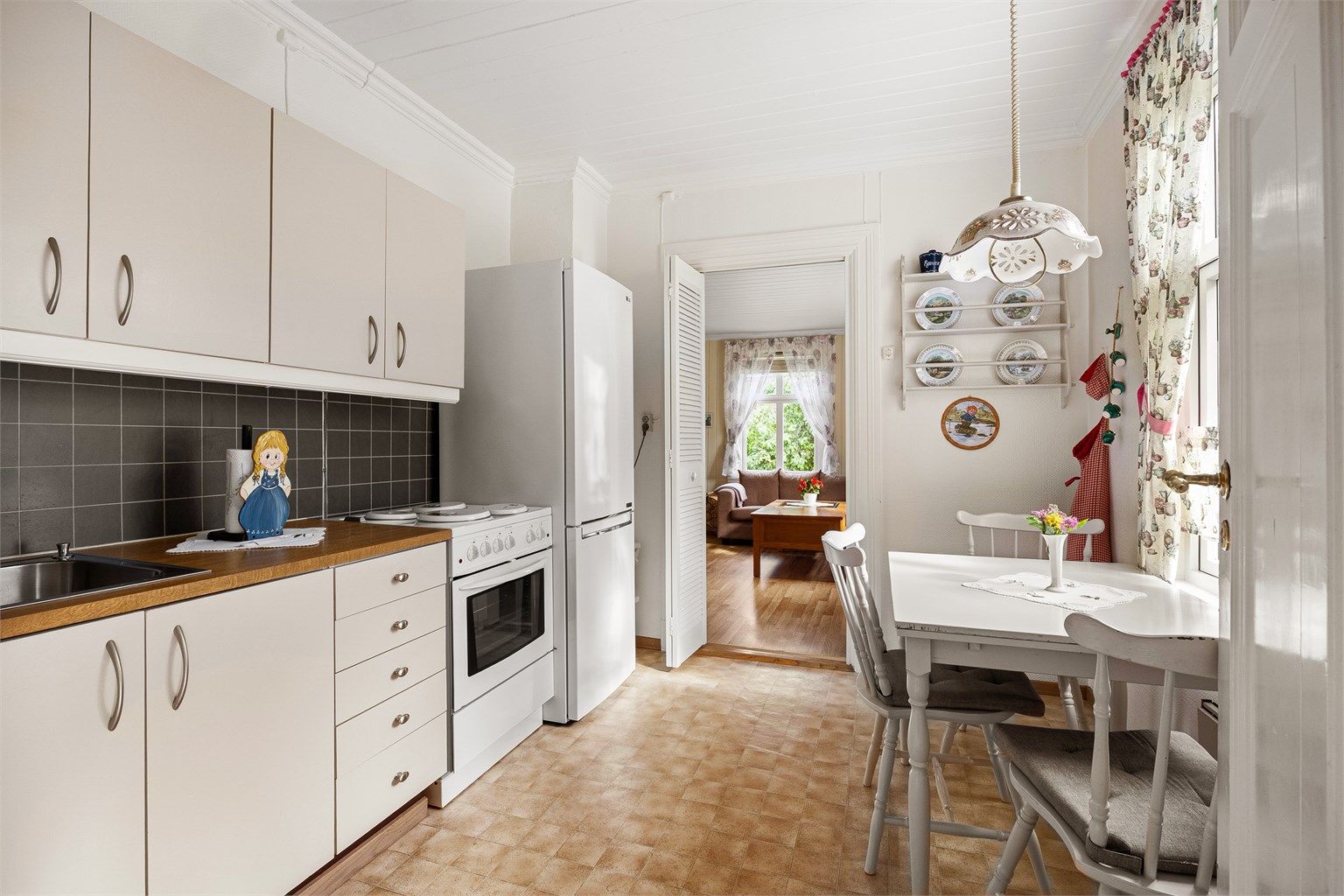 Kjøkken i første etasje med glatte fronter, laminert benkeplate og plass til spisebord.