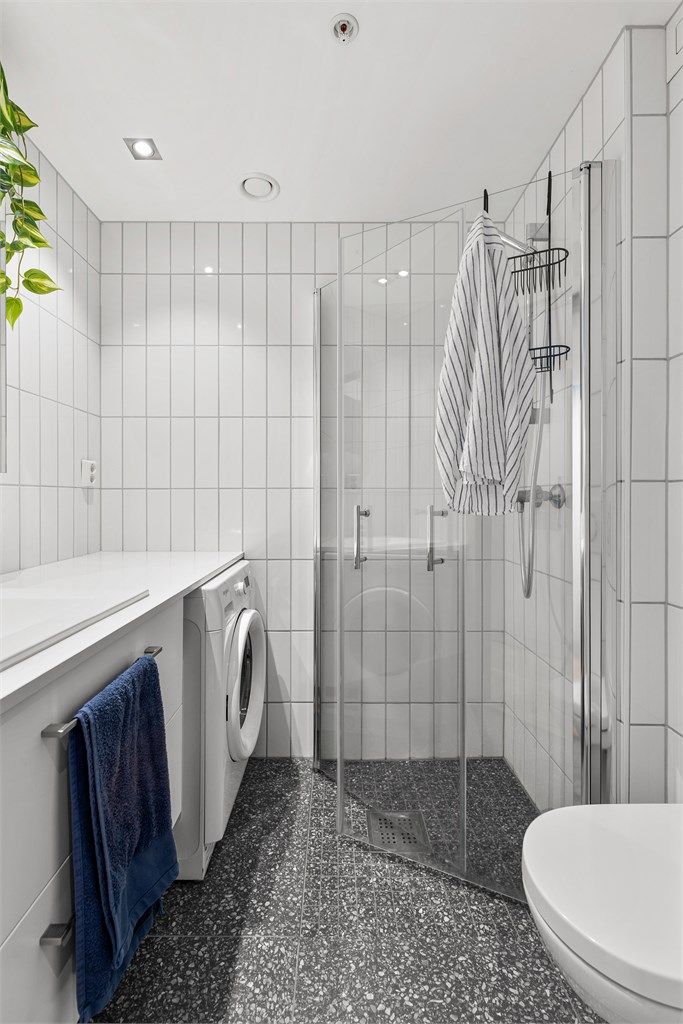 Baderom fra byggeår med flislagt gulv med varmekabler og flislagte vegger.