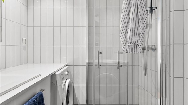 Baderom fra byggeår med flislagt gulv med varmekabler og flislagte vegger.