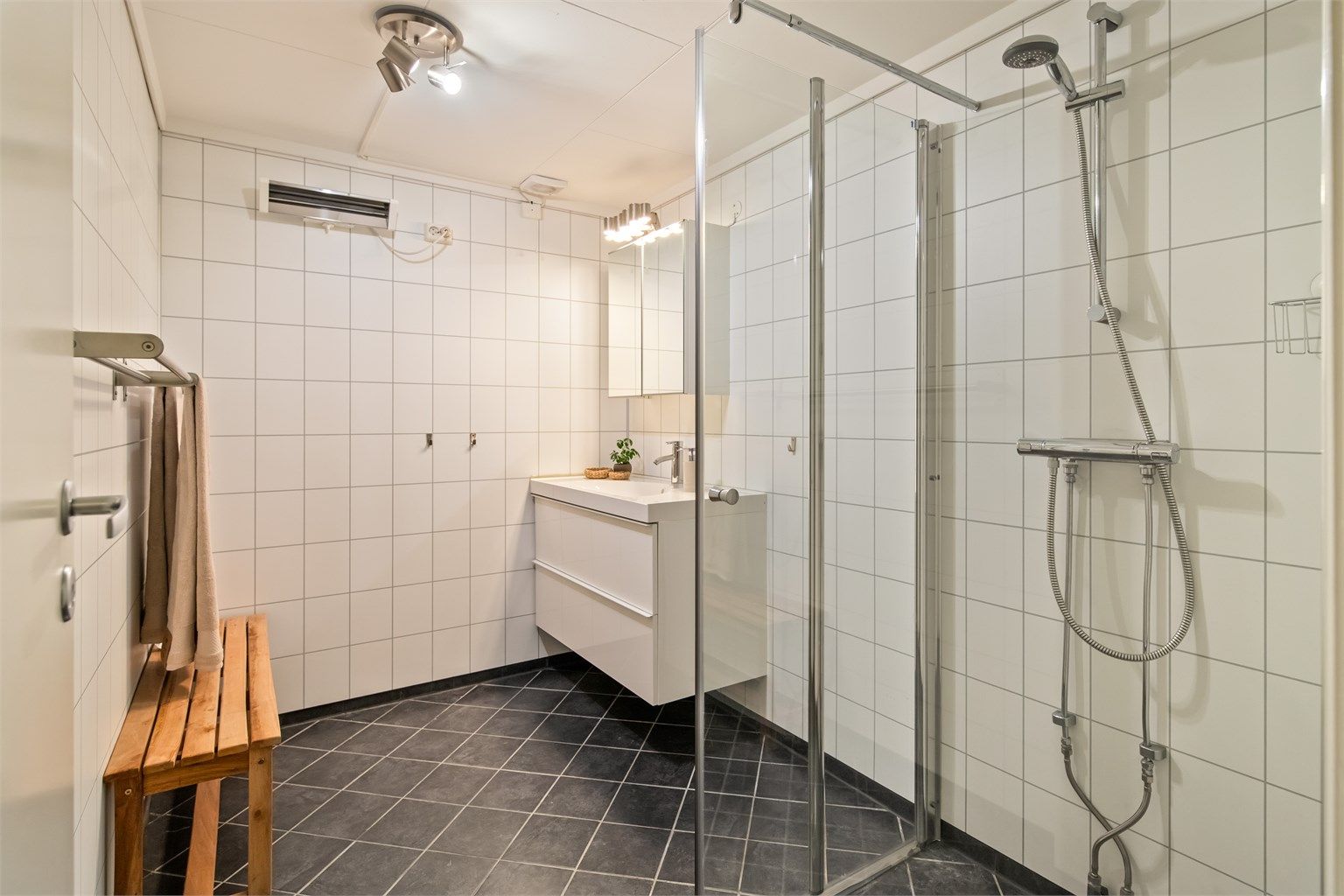 Ett av to bad i kjelleren. Badet ble oppgradert i 2013/2014. Det har fliser på gulvet og veggflater med baderomsplater. 