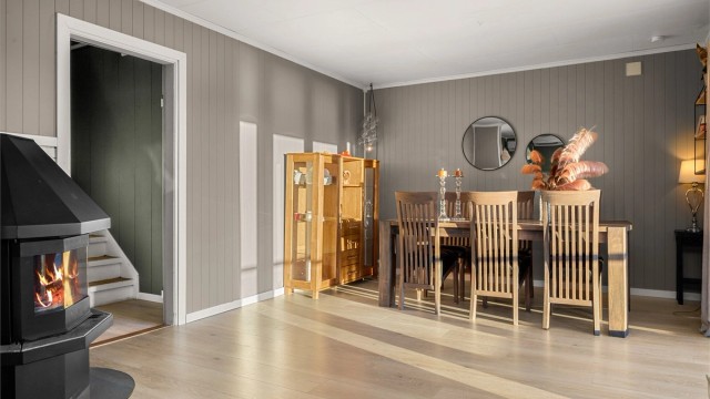 Stuen har god plass til et spisebord i en åpen og innbydende løsning. Boligen er oppvarmet med varmepumpe og vedovn i stuen, samt en varmepumpe i underetasjen som gir effektiv og behagelig oppvarming.
