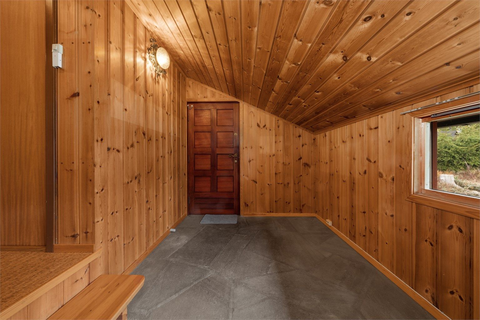 Entréen i første etasje har slitesterke skiferfliser på gulvet og panel på vegger og i himling.