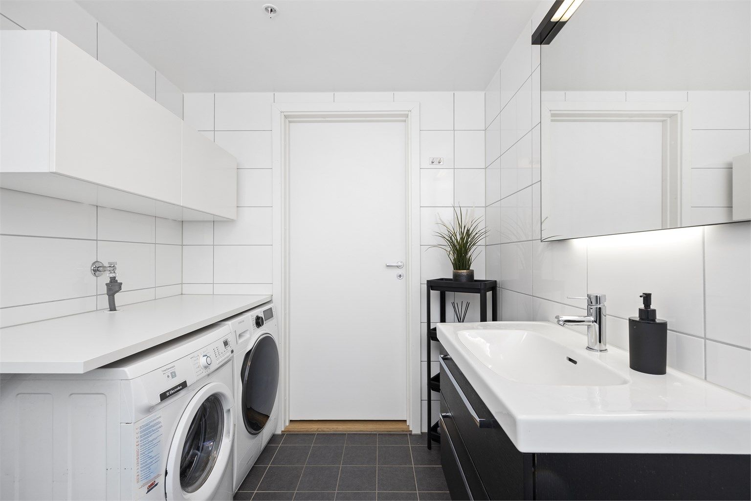 Badet er utstyrt med vegghengt toalett og dusjhjørne med innfellbare glassdører i herdet glass, m.m.