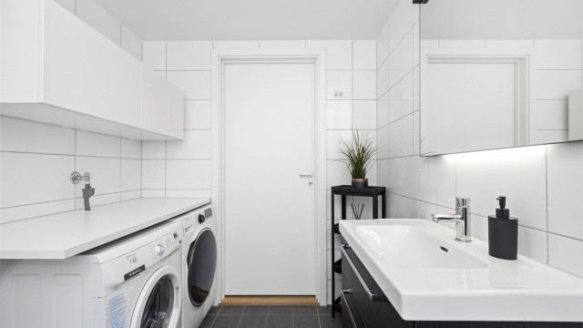 Badet er utstyrt med vegghengt toalett og dusjhjørne med innfellbare glassdører i herdet glass, m.m.