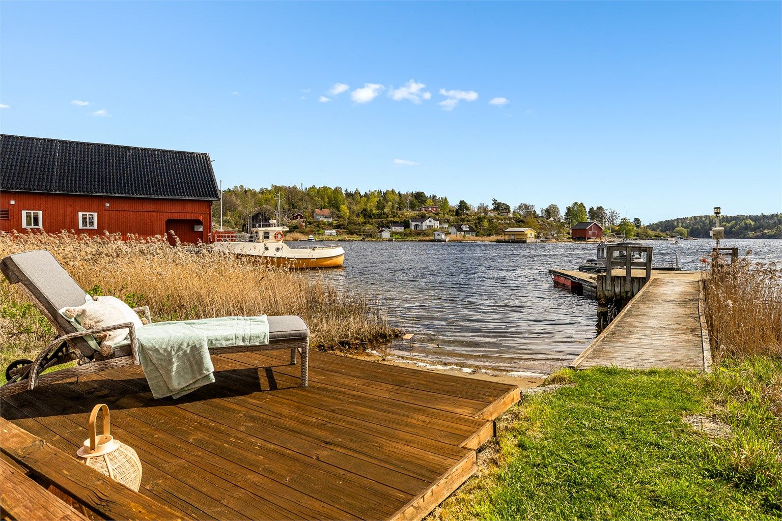 En liten privat strand og brygge med plass til flere båter.