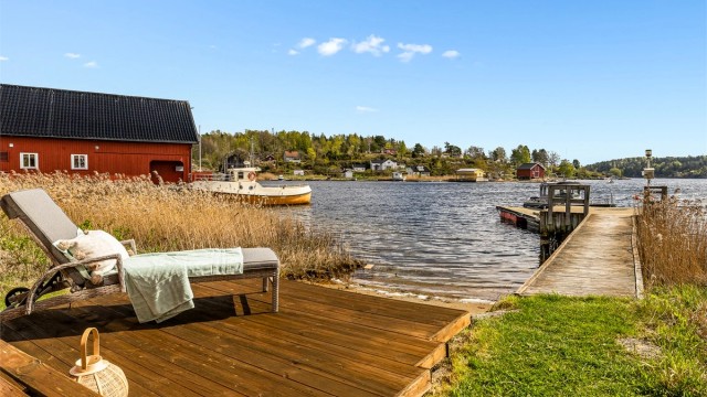 En liten privat strand og brygge med plass til flere båter.