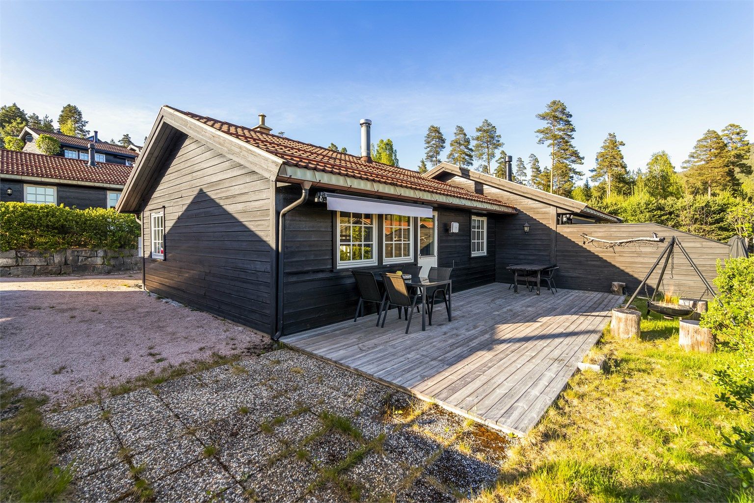 Terrassen er belagt med terrassebord, mens en tilliggende platting har betongheller.