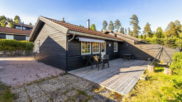 Terrassen er belagt med terrassebord, mens en tilliggende platting har betongheller.