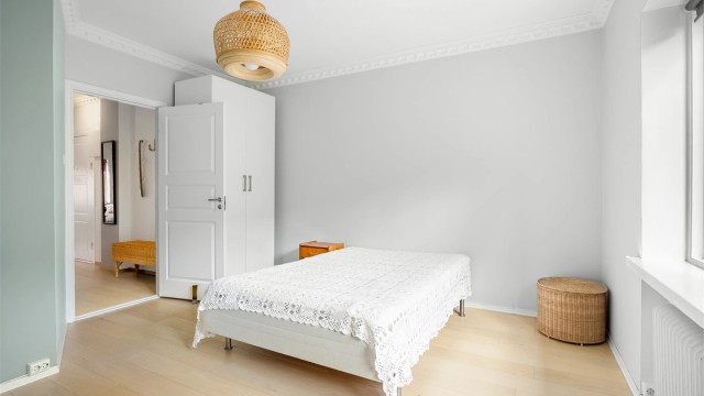 Stort og romslig hovedsoverom mot bakgården med god plass til dobbeltseng, tilhørende nattbord på begge sider og garderobeskap.