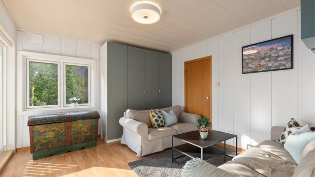 Tv-stuen har laminatgulv og plass til både sofagruppe og oppbevaring.