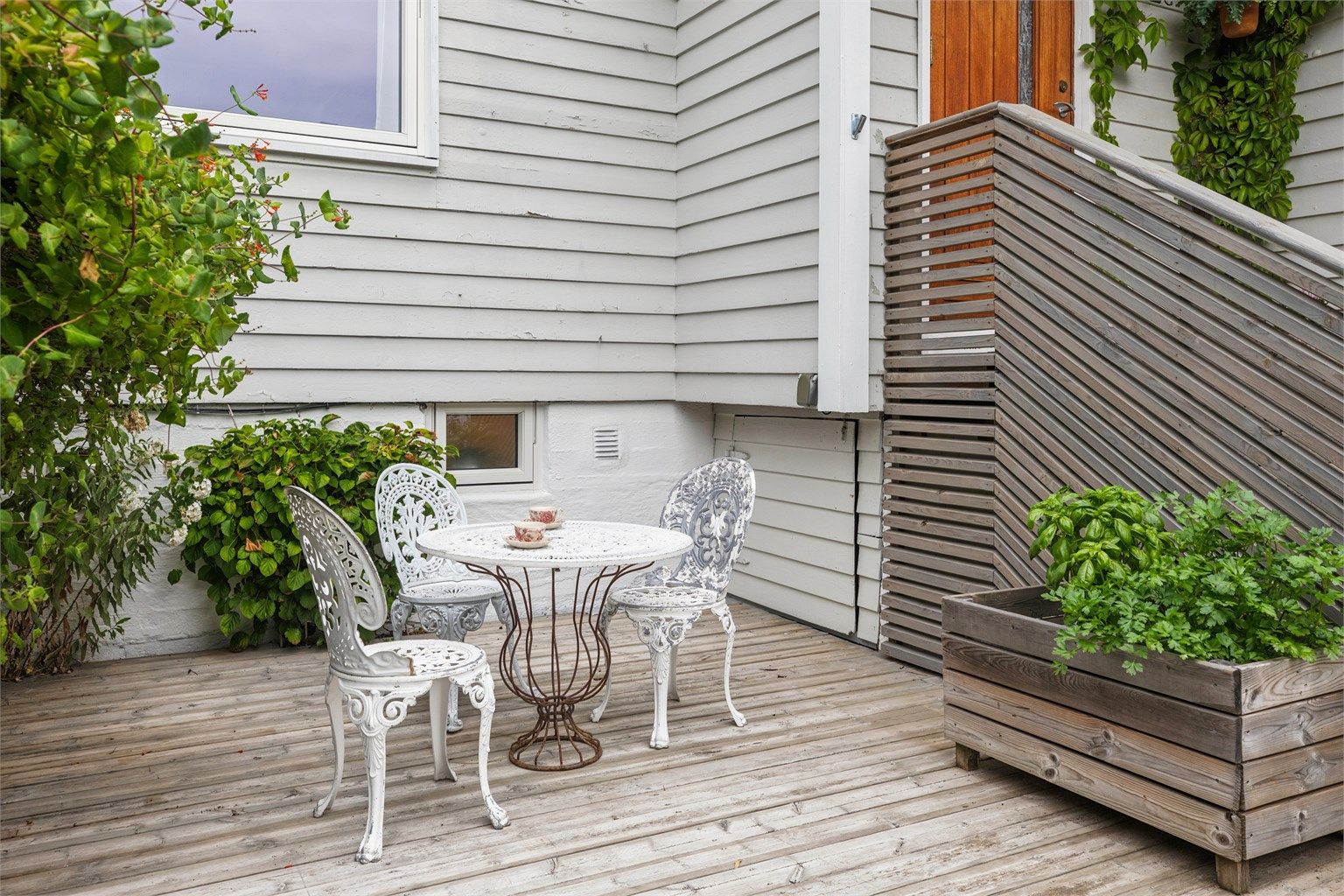 Hyggelig hage og markterrasse ved boligens inngangsparti.