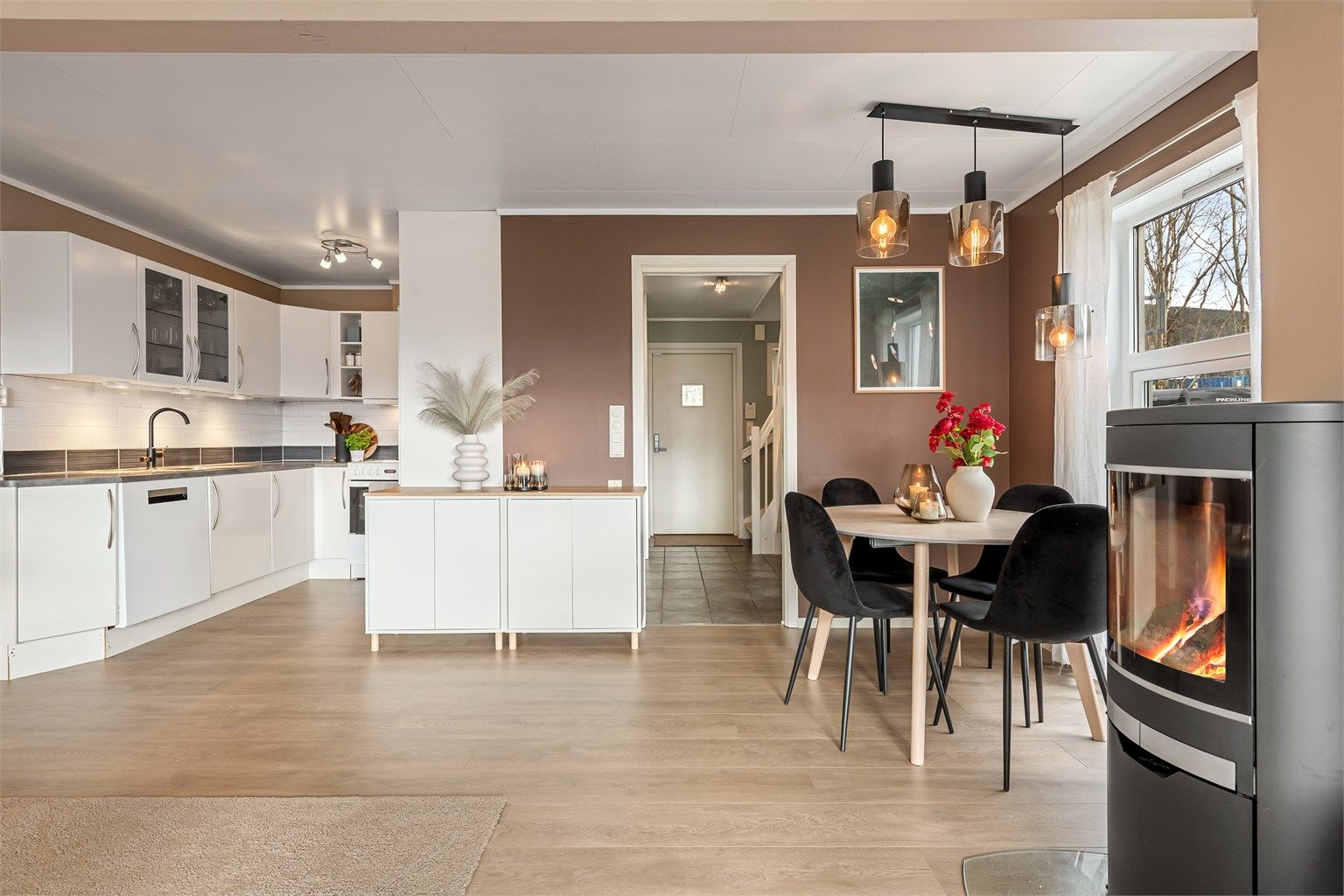 En peisovn med glassdør gir lun varme, supplert av en effektiv luft-til-luft-varmepumpe.