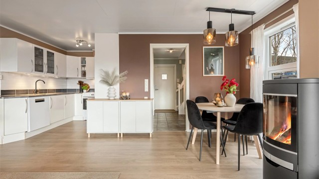 En peisovn med glassdør gir lun varme, supplert av en effektiv luft-til-luft-varmepumpe.