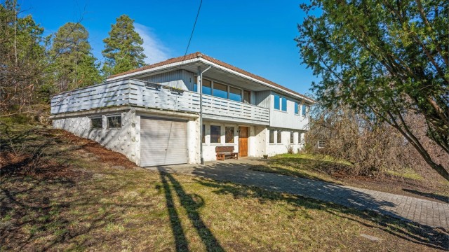Gruset biloppstillingsplass foran den integrerte garasjen på 20 m².