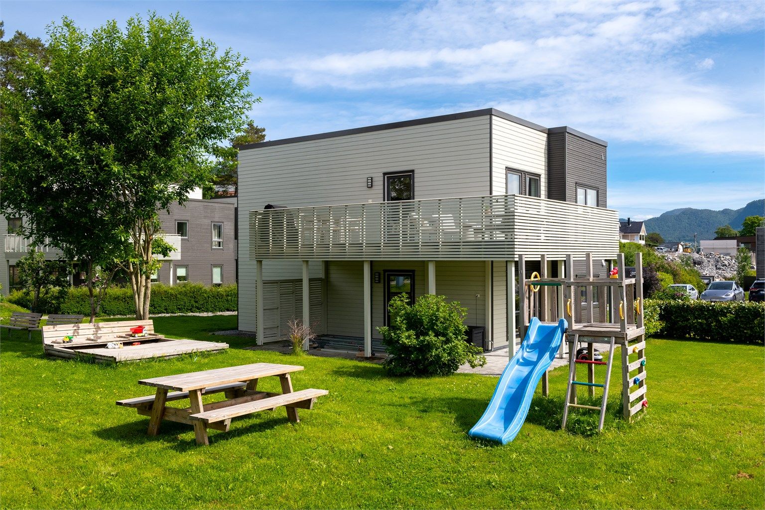 Sameiets tomt er pent opparbeidet med plenarealer og beplantning.