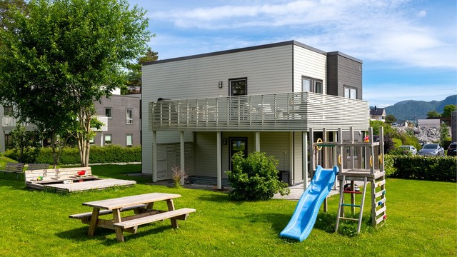 Sameiets tomt er pent opparbeidet med plenarealer og beplantning.