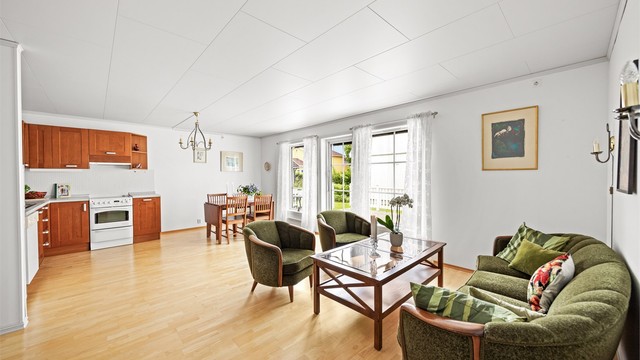 Stuen har god plass til både sofagruppe og spisebord, og en takhøyde på ca. 2,40 meter.