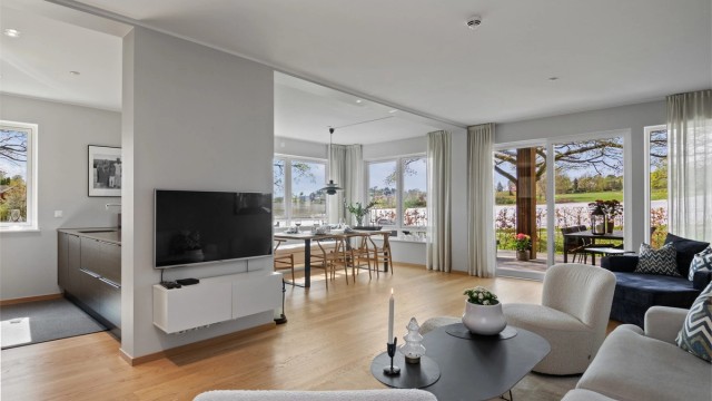 Stuen ligger i åpen løsning med kjøkkenet, og sammen danner de et stort, innbydende allrom med fine, definerte soner for møblering.