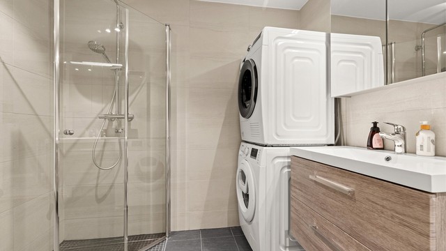 Badet er lyst og pent med flislagte overflater og gulvvarme. Innredningen er nyere med glatte skuffefronter og heldekkende servant.