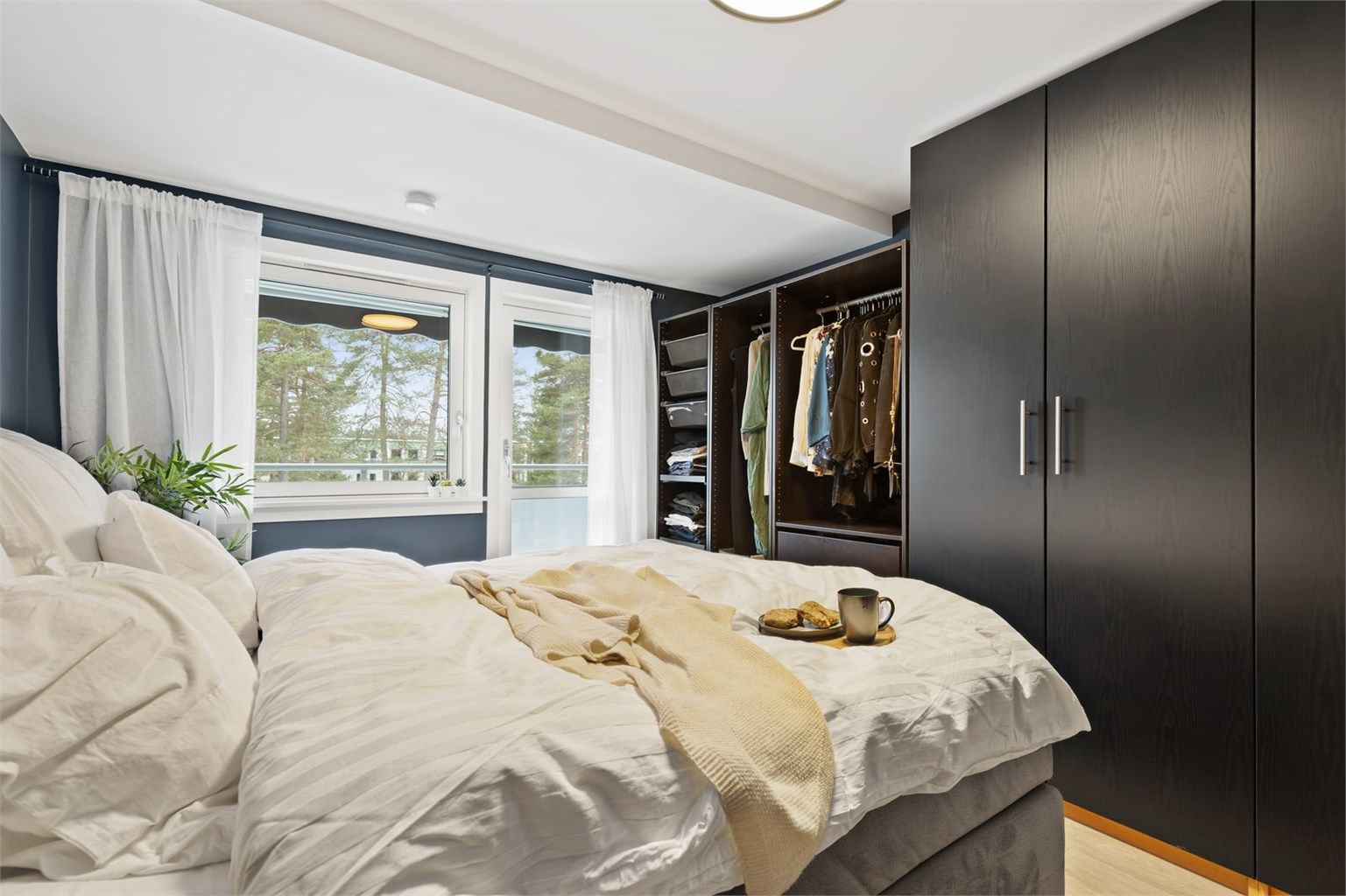 Rommet har en praktisk garderobeløsning som gir rikelig med oppbevaringsplass.