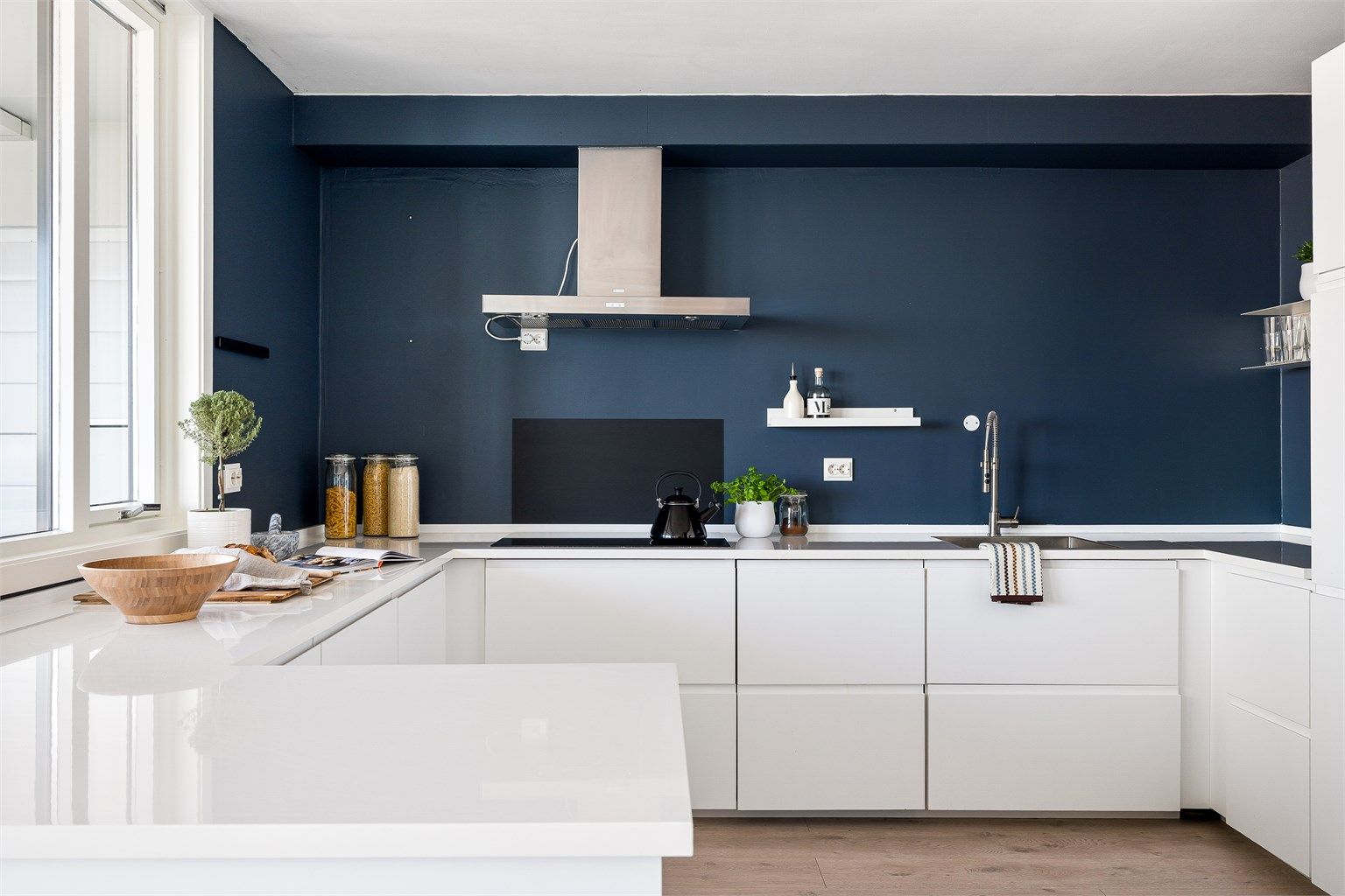 Kjøkkenet har svært god skap- og benkeplass med integrerte hvitevarer og hvite slette fronter.  