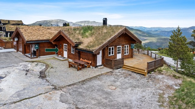 Hytten ligger på toppen av Vrådal med fantastisk utsikt over fjellene. Hytten er en duohytte. Og det er hytten til høyre som er til salgs.