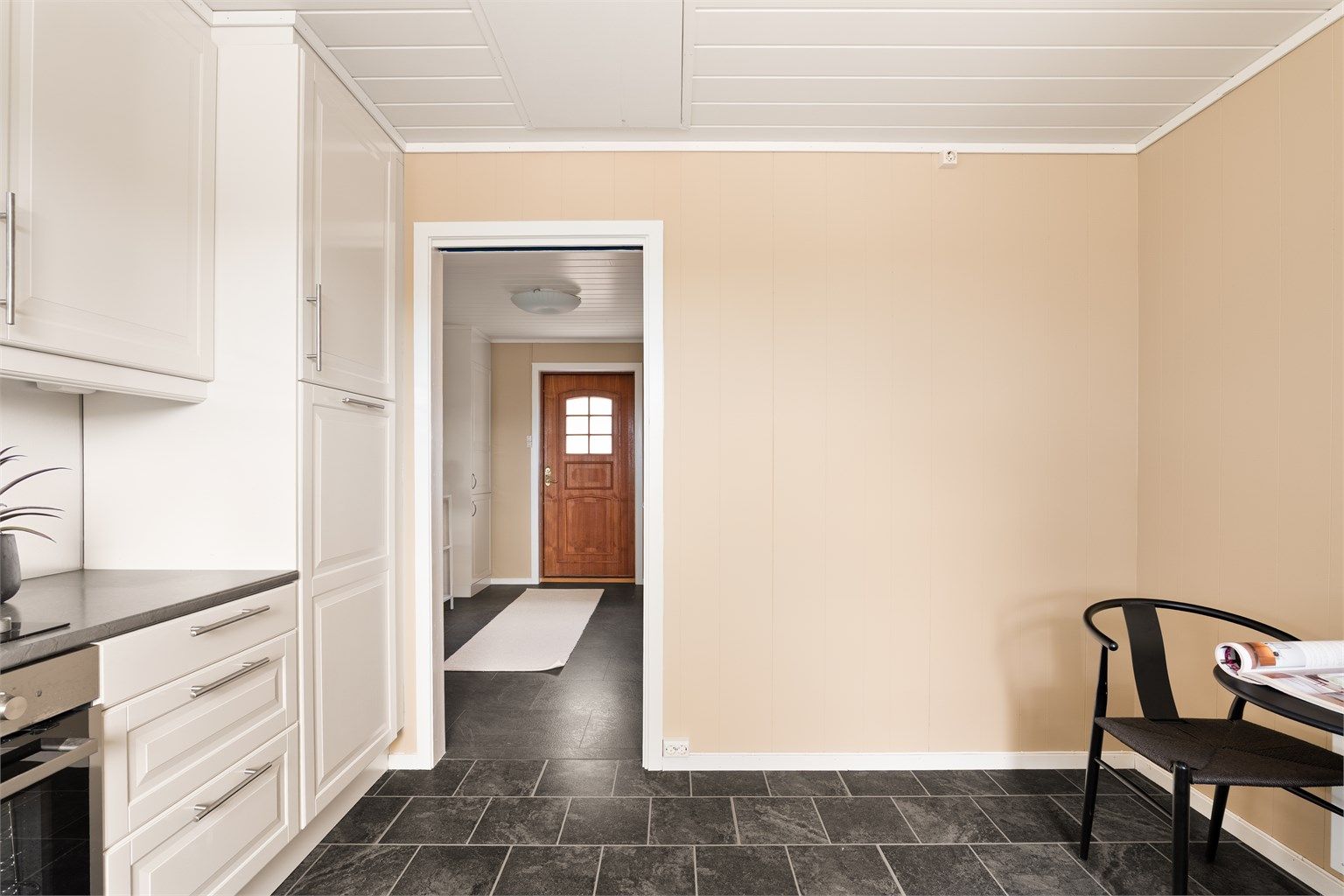 Fra den romslige entreen kan handleposene enkelt bæres rett inn til kjøkkenet.