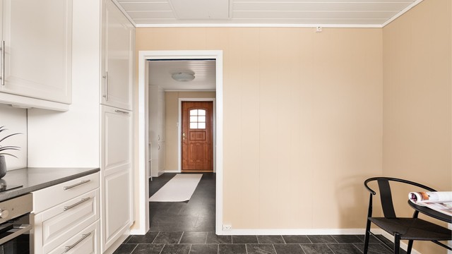 Fra den romslige entreen kan handleposene enkelt bæres rett inn til kjøkkenet.