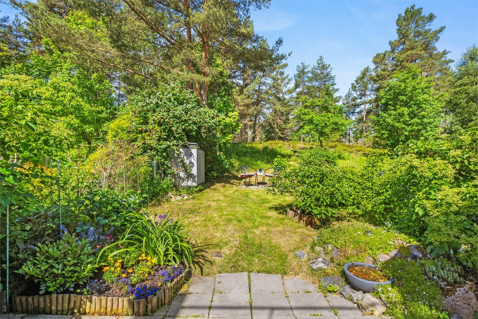 Hagen er en usjenert oase med direkte utgang til skogholtet bak huset.