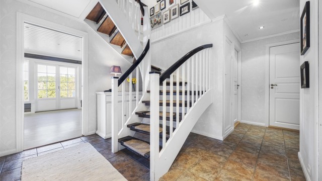 Flislagt hall med gulvvarme og downlights.