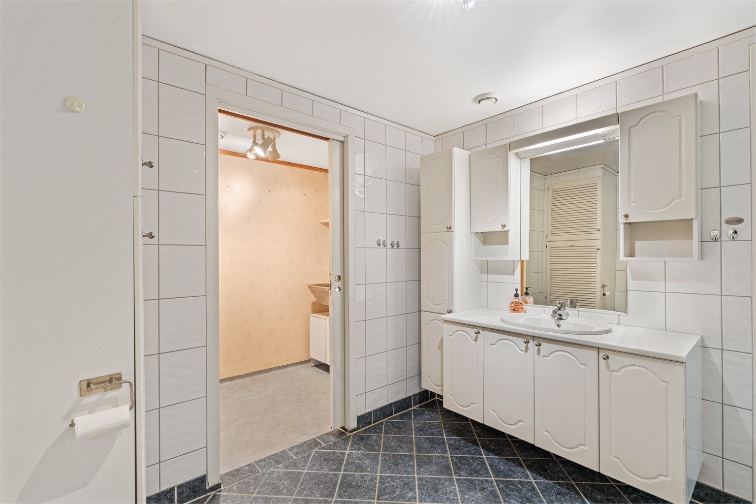 Fra badet er det praktisk tilgang til et separat vaskerom.