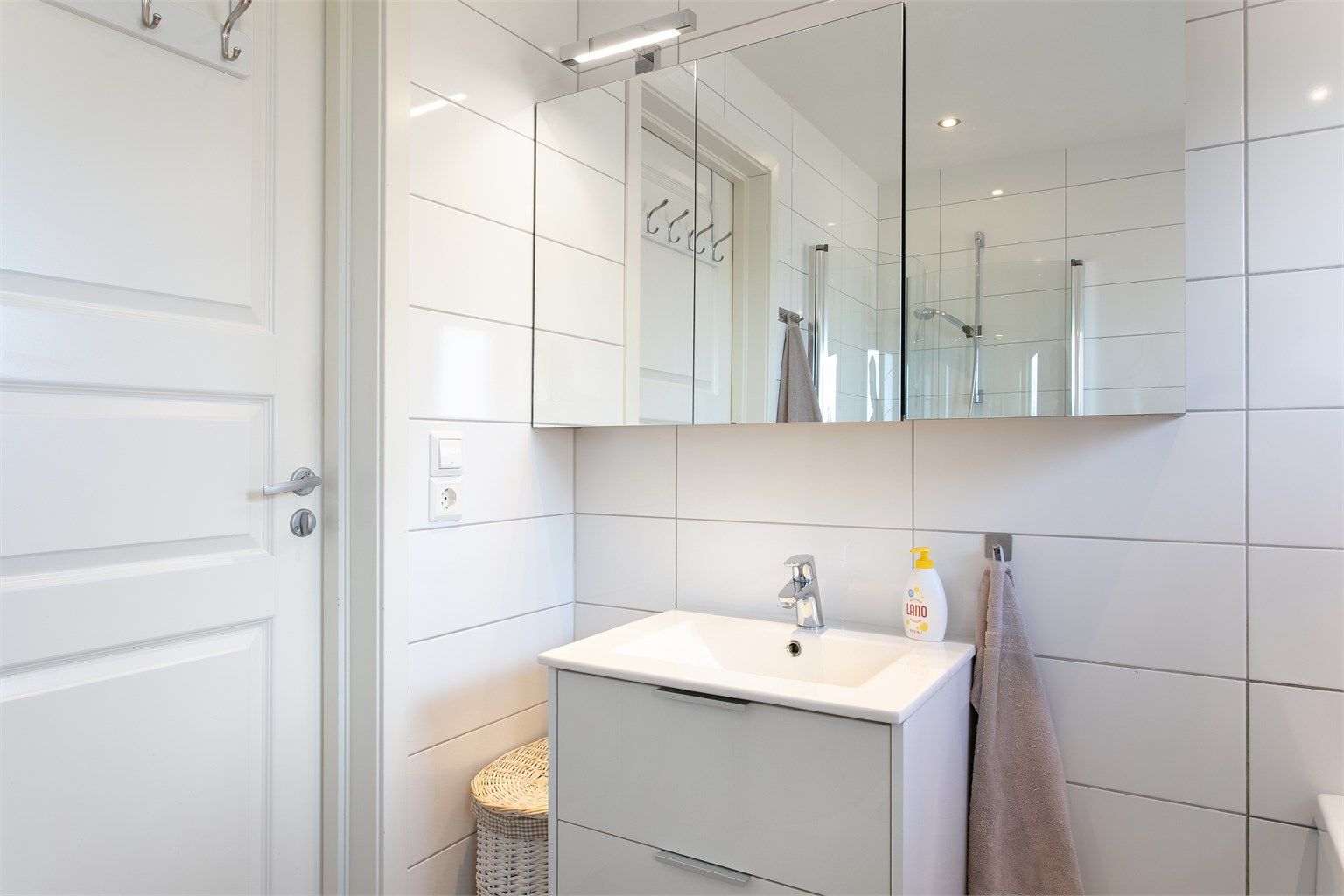 Innredning med skuffer og nedfelt servant med ett-greps armatur. Speilskap med overlys over servant