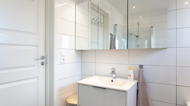 Innredning med skuffer og nedfelt servant med ett-greps armatur. Speilskap med overlys over servant