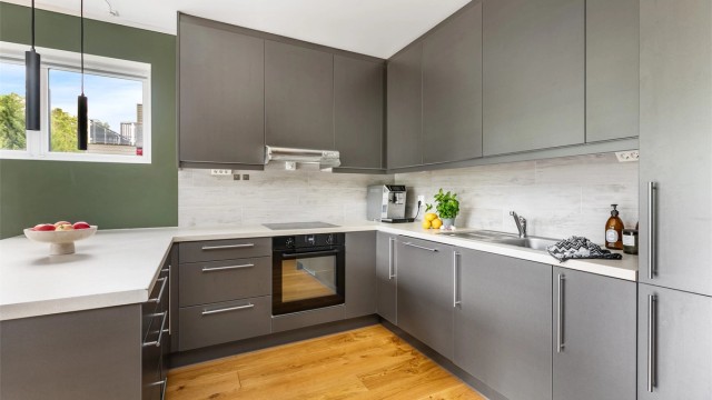 Mange oppbevaringsmuligheter kombinert med meterlange arbeidsflater gjør kjøkkenet meget praktisk. Alle hvitevarer er integrert.