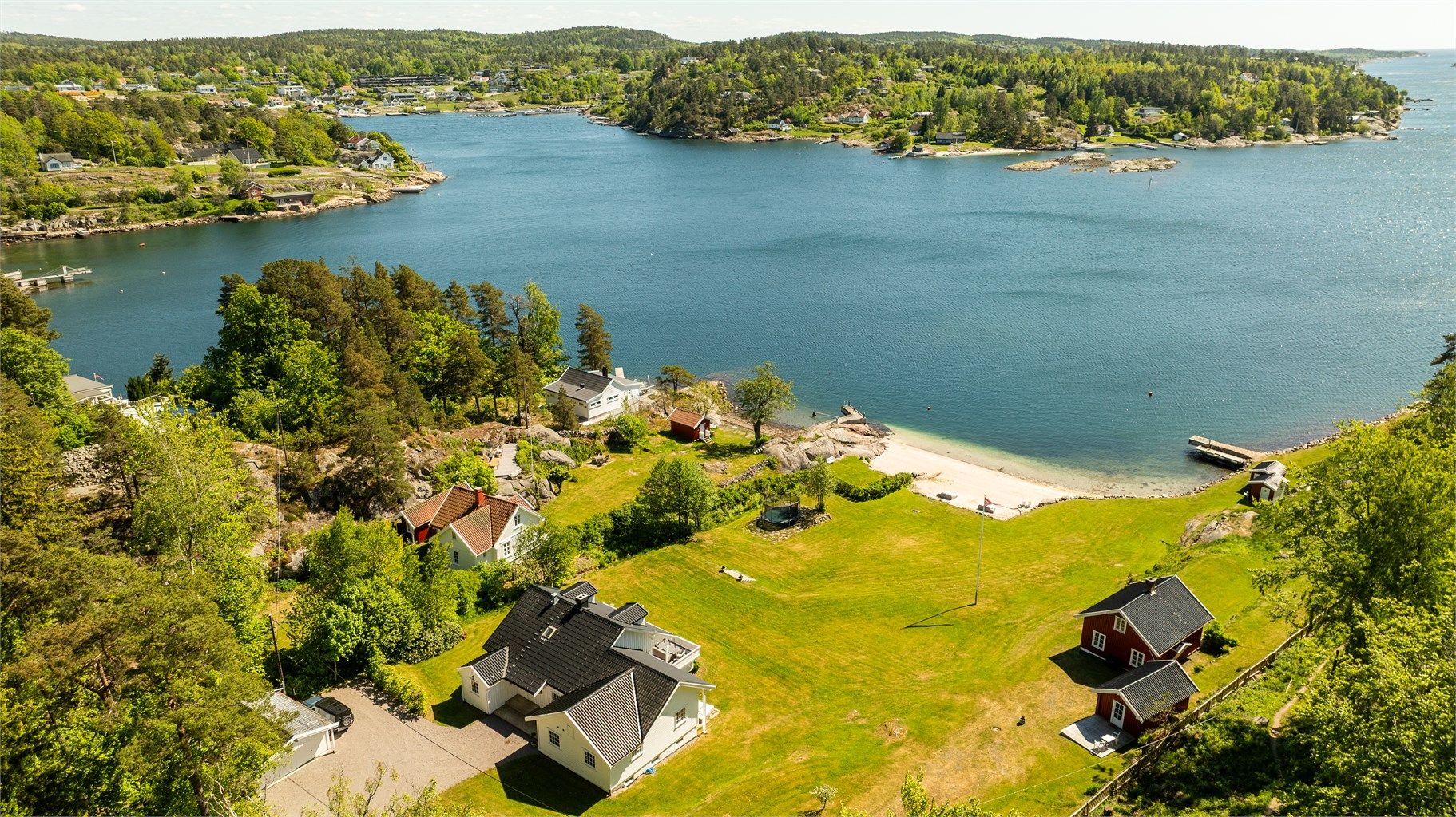 Unik, usjenert og idyllisk strandeiendom med to eneboliger, brygge, stor tomt og fantastisk utsikt – sjelden mulighet!