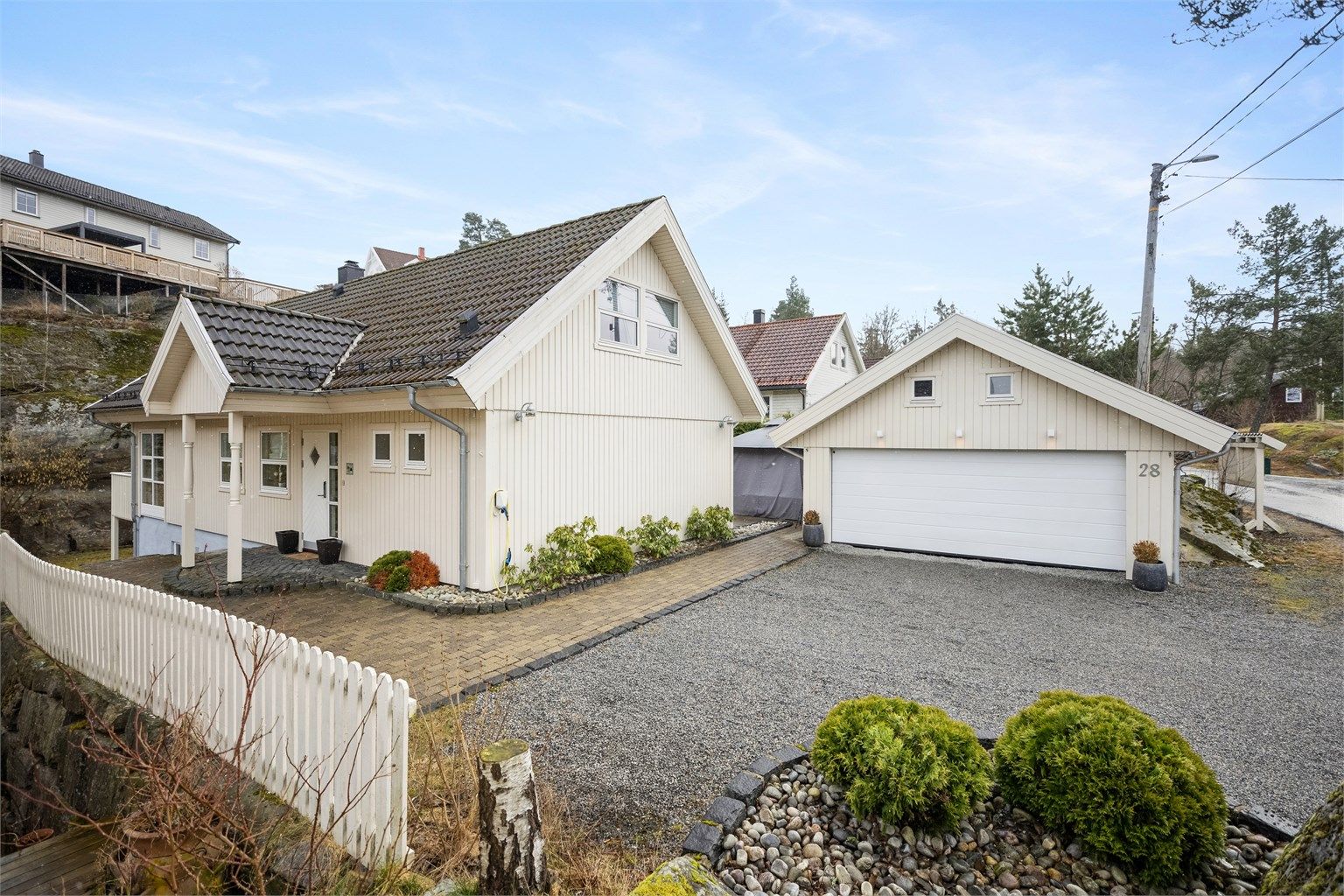 Eiendommen er flott opparbeidet med gruset gårdsplass, belegningssten, store terrasseområder og usjenert hage. 