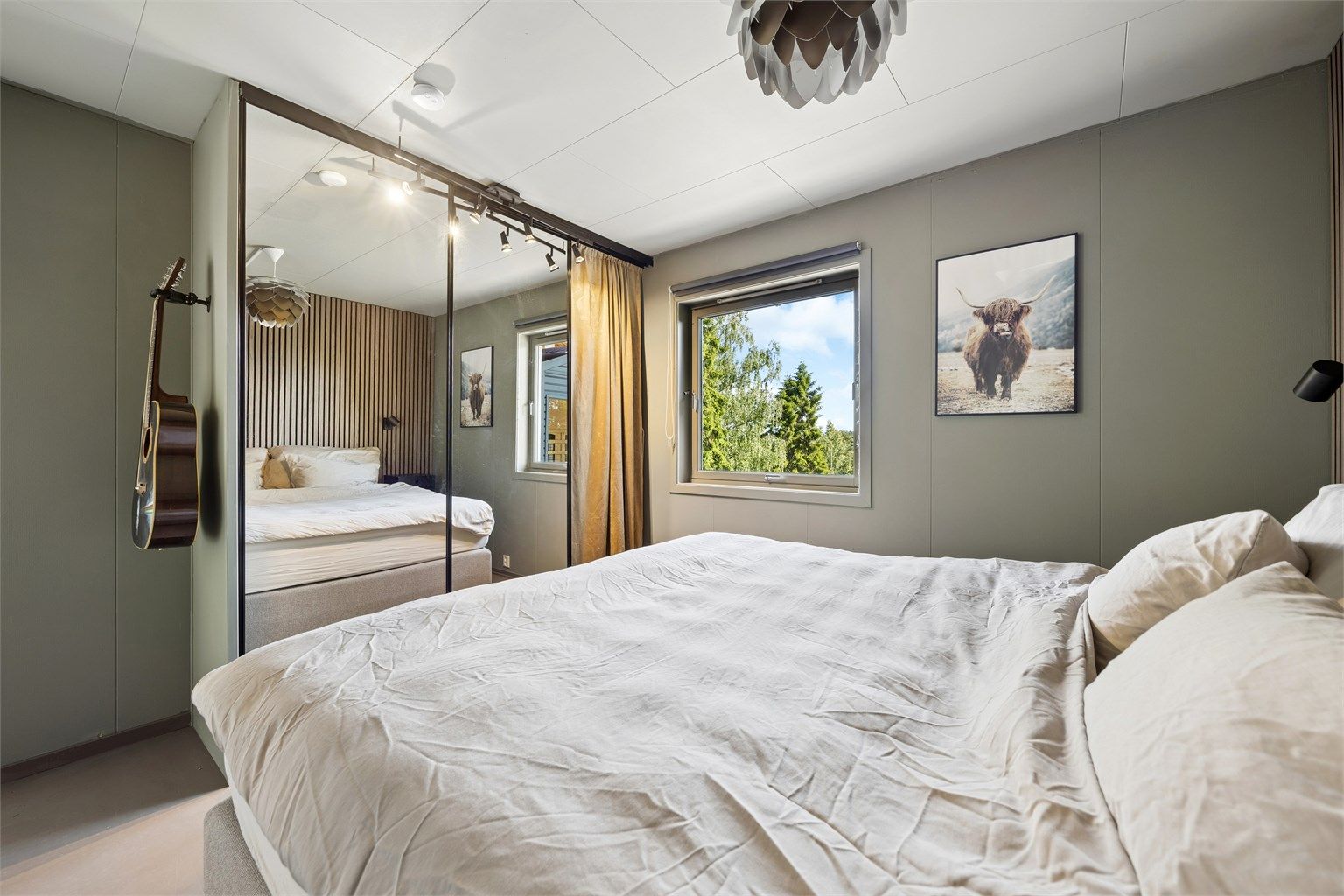 Stor skyvedørsgarderobe gir rikelig med oppbevaringsplass og bidrar til et ryddig og funksjonelt soverom.