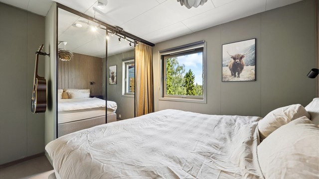 Stor skyvedørsgarderobe gir rikelig med oppbevaringsplass og bidrar til et ryddig og funksjonelt soverom.