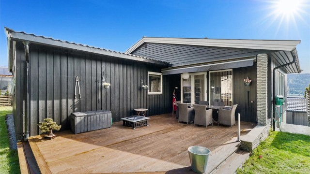 Hyggelig terrasse utenfor boligens stue, trapp ned til gårdsplassen