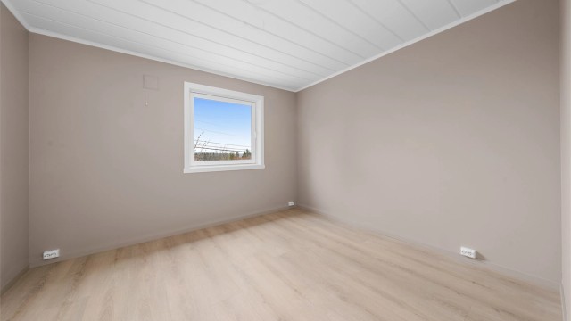 Rommet har malte, glatte flater og laminat på gulvet.