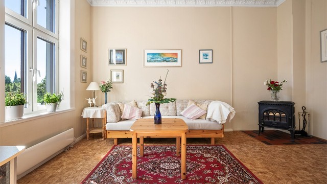 Leiligheten varmes med en kombinasjon av elektrisitet og en koselig peis i stuen.