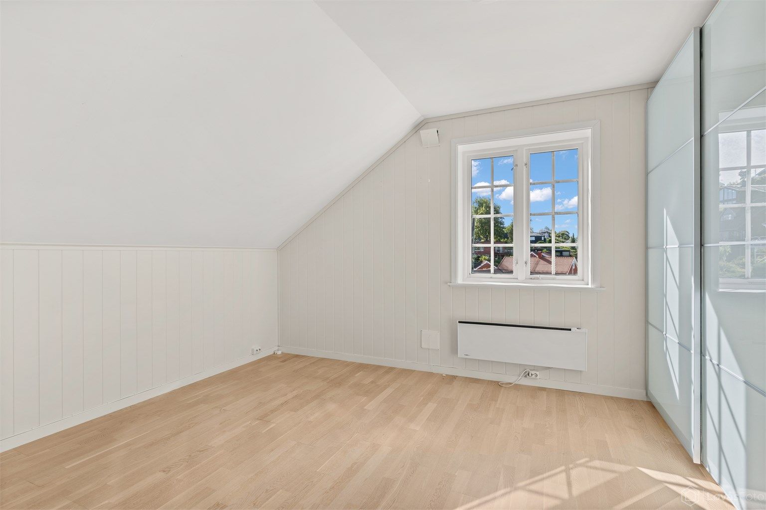 Soverom i andre etasje innredet med romslig skyvedørsgarderobe.